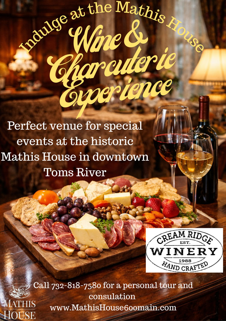 A wooden table with wine glasses and a large charcuterie board of meats, cheeses, fruits, and crackers. Text advertises the Wine & Charcuterie Experience at the Mathis House, a charming bed and breakfast in Toms River NJ. Cream Ridge Winery logo is shown.